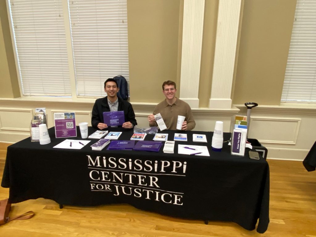 Stanley and Gavin help staff an MCJ table at a Homeowners Empowerment seminar in Hattiesburg, MS under the supervision of Ashley.